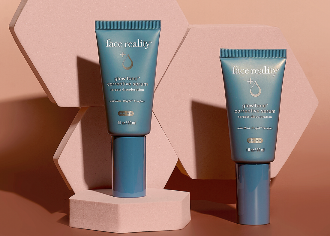 Two blue skincare serum tubes on a pink geometric background