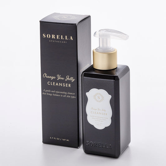 A black pump bottle with a clear cap labeled 'Sorella Apothecary Orange you Jelly Cleanser' next to its packaging box.